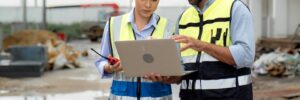 two construction workers look at a laptop